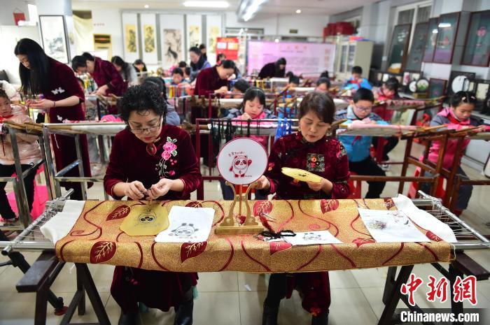 江西省級非遺豫章繡傳承人手把手指導小學生繡制2022年北京冬奧會吉祥物“冰墩墩”形象?！∮髟屏?攝