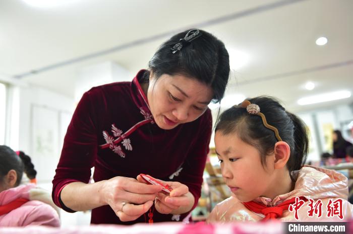 江西省級非遺豫章繡傳承人手把手指導小學生繡制2022年北京冬奧會吉祥物“冰墩墩”形象?！∮髟屏?攝
