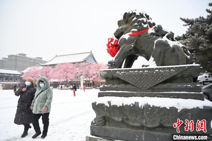 2月13日，民眾在呼和浩特市大召廣場雪中漫步?！⑽娜A 攝