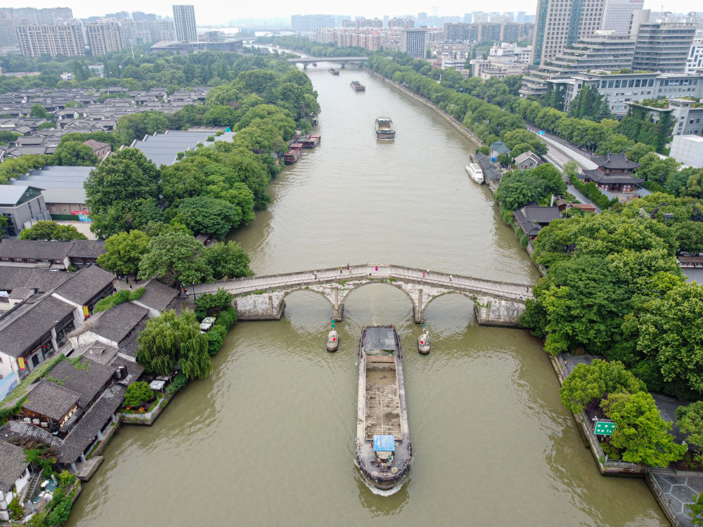 5月27日，一艘貨船駛過京杭大運河南端標(biāo)志建筑杭州拱宸橋。(無人機(jī)照片)新華社記者江漢 攝