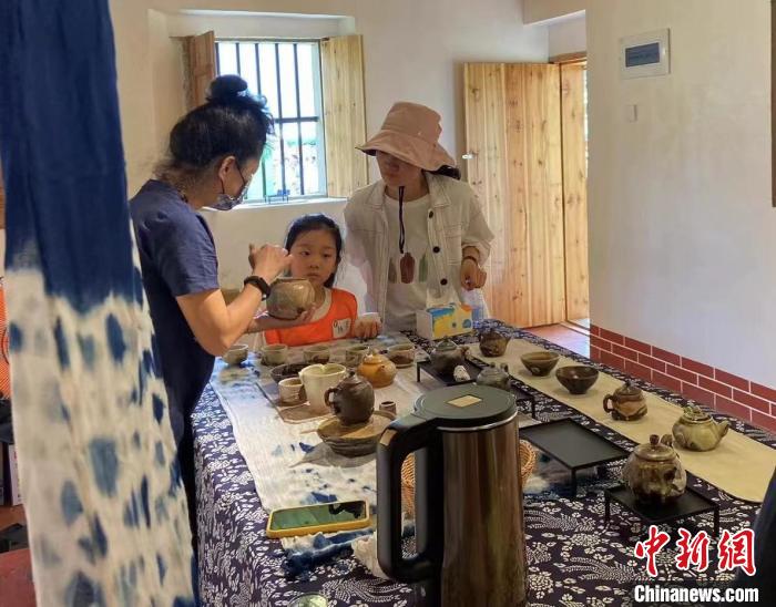 圖為：游客正在咨詢臺灣柴燒作品?！∪~秋云 攝