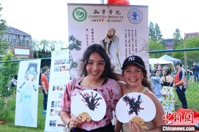 孩子們展示自己的吹墨畫團(tuán)扇作品。　魯汶孔子學(xué)院供圖