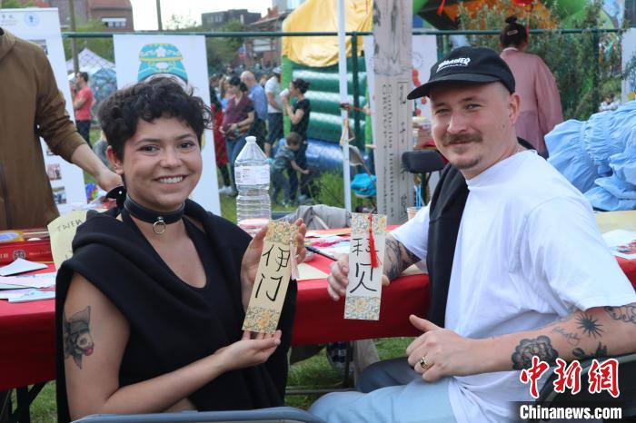 當(dāng)?shù)孛癖娫跐h字體驗(yàn)工作坊展示自己手寫的中文名書簽?！◆斻肟鬃訉W(xué)院供圖