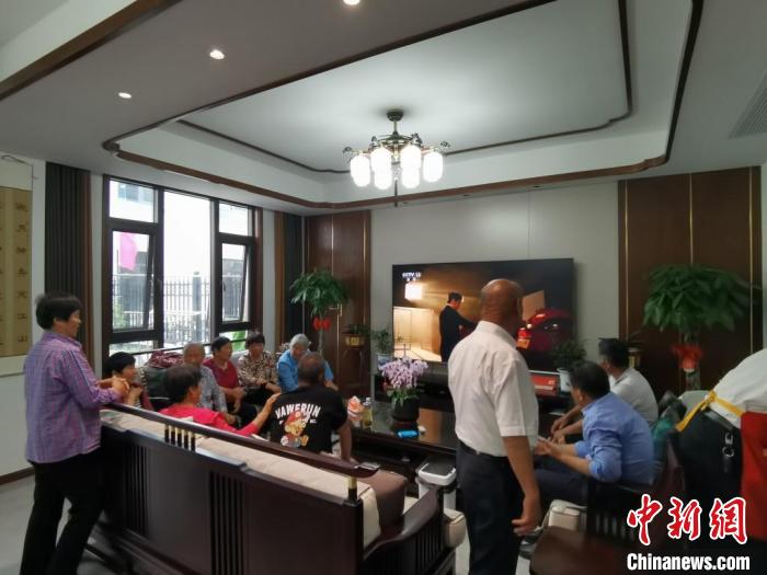 親友們集中在費(fèi)俊龍家中觀看返程的視頻?！＄娚?攝