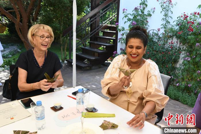 圖為嘉賓展示包粽子成果?！“亓种袊幕行墓﹫D。