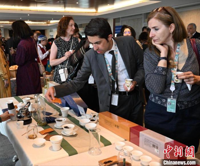 現(xiàn)場觀眾觀看中國展臺茶藝表演、了解茶文化。　靖樹 攝