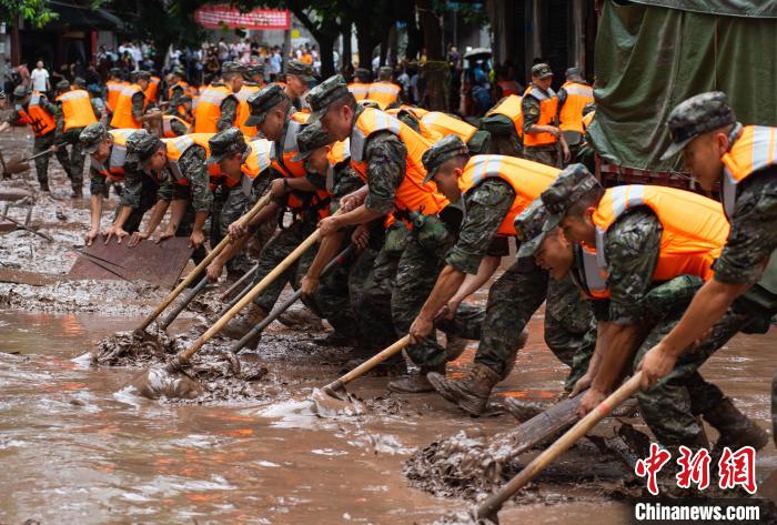 7月4日，萬州區(qū)五橋街道，武警官兵清理街道上的淤泥。　冉孟軍 攝