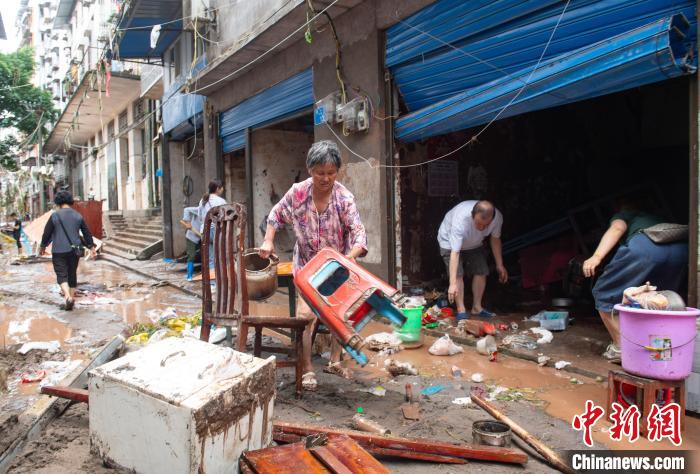 7月4日，萬州區(qū)五橋街道，洪水退去后，居民搶救生活物資?！∪矫宪?攝