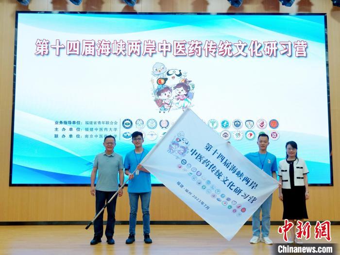 共青團(tuán)福建省委副書記吳雪(右一)、福建中醫(yī)藥大學(xué)黨委副書記林羽(左一)為兩岸學(xué)生代表頒授營旗?！≡S燁婷 攝