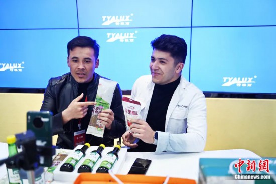 2023年3月，甘肅省慶陽市環(huán)縣電商創(chuàng)業(yè)孵化基地內(nèi)，來自蘭州文理學(xué)院的塔吉克斯坦留學(xué)生正在協(xié)助主播直播帶貨當(dāng)?shù)剞r(nóng)特產(chǎn)品。李亞龍 攝