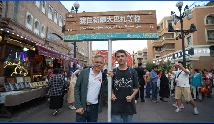 潘維廉和維吾爾族青年伊木蘭“打卡”大巴扎。主辦方供圖
