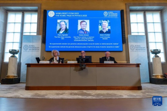 10月3日，在瑞典斯德哥爾摩舉行的2023年諾貝爾物理學(xué)獎公布現(xiàn)場，屏幕上顯示獎項(xiàng)得主皮埃爾·阿戈斯蒂尼（左）、費(fèi)倫茨·克勞斯（中）和安妮·呂利耶的照片。新華社發(fā)（魏學(xué)超攝）