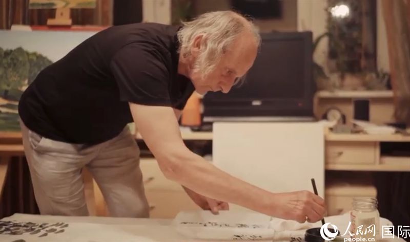 伊戈?duì)枴げ紶枛|諾夫在畫(huà)作上題詞。人民網(wǎng)記者 馬天翼攝