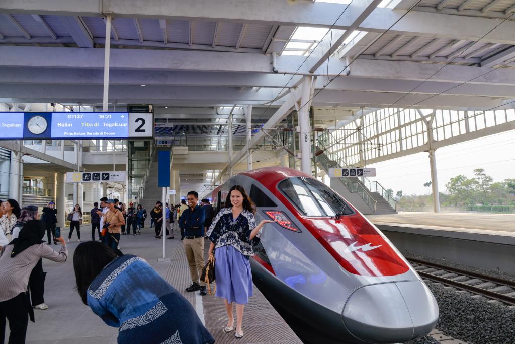 10月17日，在印度尼西亞萬隆德卡魯爾站，乘客在站臺(tái)上和雅萬高鐵高速動(dòng)車組列車合影。
