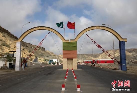 5月5日，瓜達(dá)爾港出入口的拱門。瓜達(dá)爾港是阿拉伯海沿岸的一座天然不凍良港，也是中巴經(jīng)濟(jì)走廊的南端起點(diǎn)。中國公司自2013年開始取得瓜達(dá)爾港的運(yùn)營權(quán)，目前各項(xiàng)工作逐步展開。盡管自然條件差、物資匱乏，但瓜達(dá)爾卻有著重要的地理位置。瓜達(dá)爾是巴基斯坦通往波斯灣和阿拉伯海的大門，距離霍爾木茲海峽僅400公里。作為一帶一路有益補(bǔ)充的中巴經(jīng)濟(jì)走廊經(jīng)濟(jì)構(gòu)架的確立，使位于巴基斯坦最南端的瓜達(dá)爾港成為中巴經(jīng)濟(jì)走廊的一個(gè)重要出?？?。<a target='_blank' href='/'><p  align=