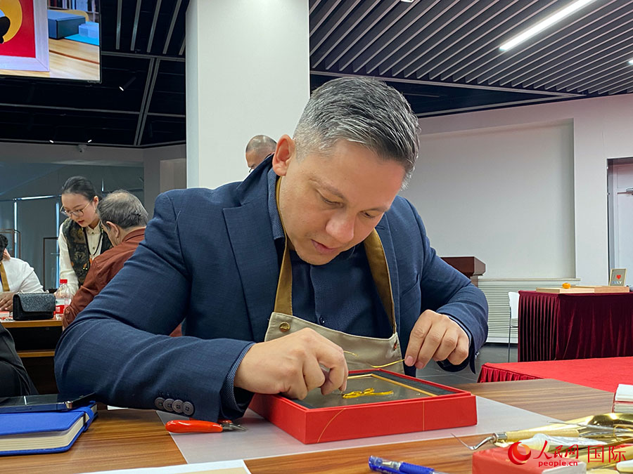 2023“一帶一路”媒體合作論壇聯(lián)合采訪團(tuán)團(tuán)員，親身體驗(yàn)景泰藍(lán)工藝。人民網(wǎng)記者 于洋攝