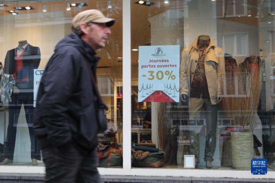   10月31日，一名男子從比利時(shí)布魯塞爾一家貼有打折信息的店鋪前走過(guò)。新華社記者 趙丁喆 攝