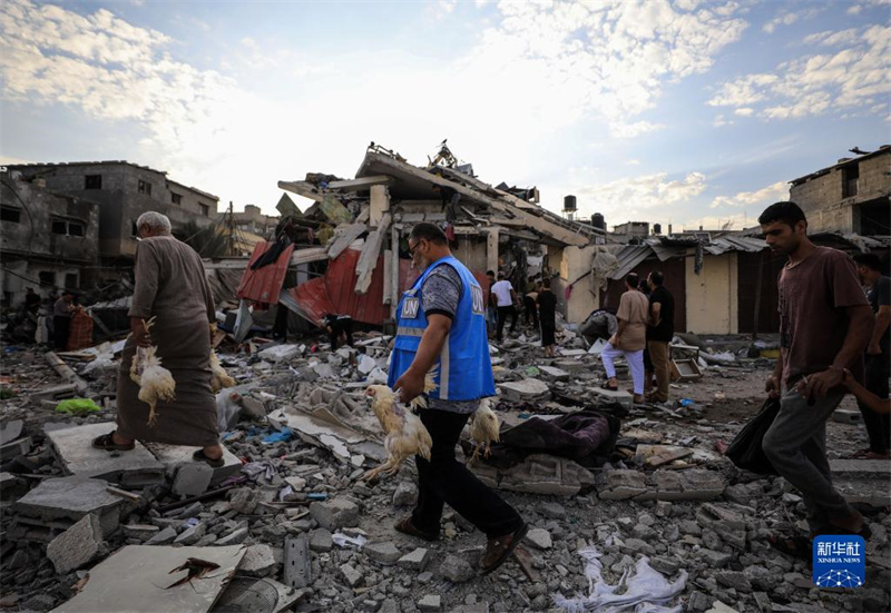 10月27日，在加沙地帶南部城市汗尤尼斯，人們經(jīng)過(guò)以軍襲擊后的房屋廢墟。