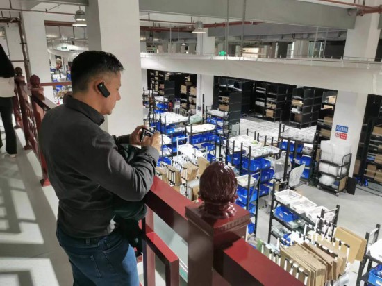 2023“一帶一路”媒體合作論壇聯(lián)合采訪團(tuán)團(tuán)員在仁和醫(yī)藥物流園拍攝記錄轉(zhuǎn)運(yùn)流程。（本報(bào)記者 黃超攝）