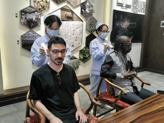 2023“一帶一路”媒體合作論壇聯(lián)合采訪團(tuán)團(tuán)員在九牛草展示館體驗(yàn)艾灸。（本報(bào)記者 黃超攝）