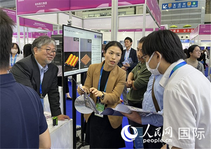 工作人員向參觀者介紹超級(jí)噴墨技術(shù)。（人民網(wǎng)記者 陳思攝）