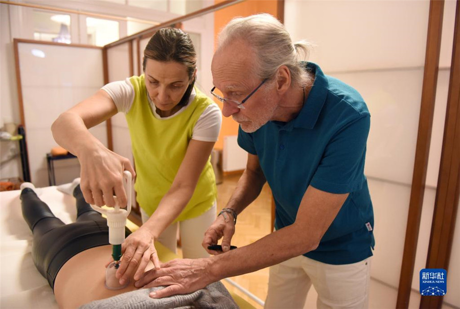 12月12日，在奧地利維也納，科格勒醫(yī)生（右）和助手在為病人進(jìn)行拔罐治療。新華社記者 賀燦鈴 攝