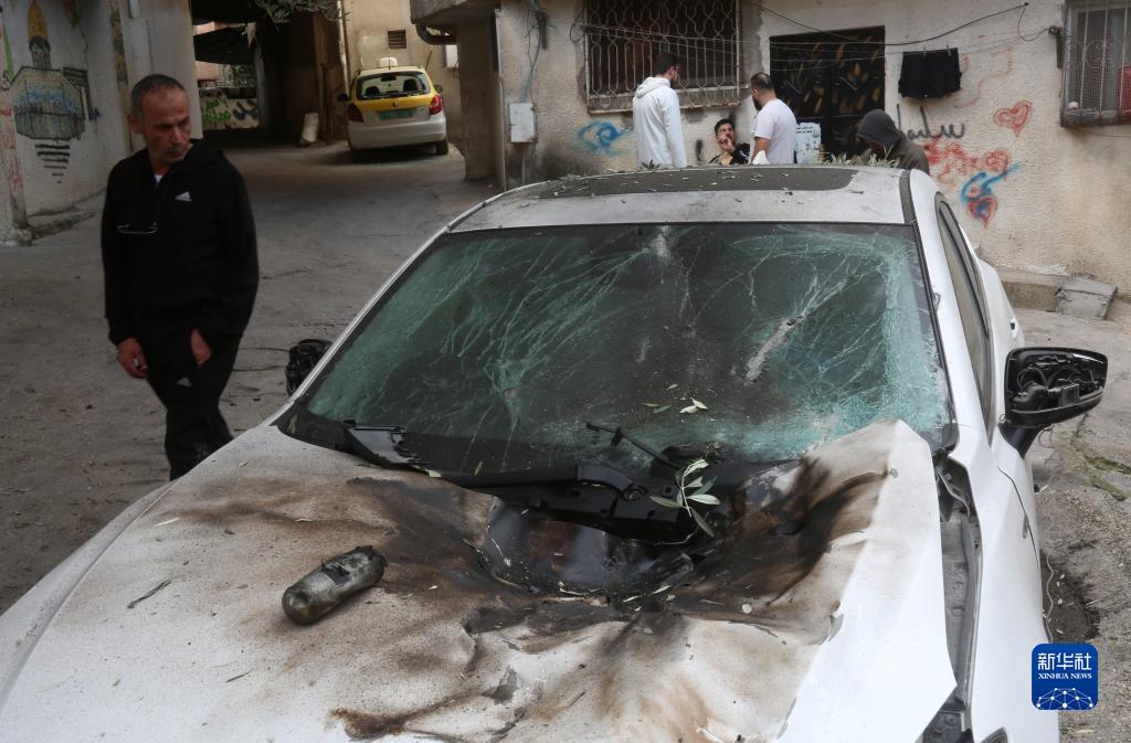 12月17日，在約旦河西岸城市圖勒凱爾姆附近的一處難民營(yíng)，人們查看在沖突中損毀的車輛。新華社發(fā)（尼達(dá)爾·艾仕塔耶?dāng)z）