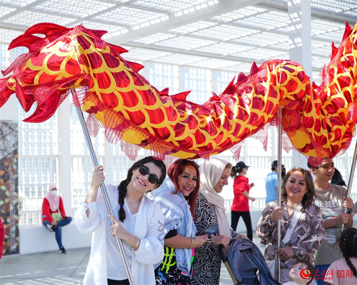 游客體驗(yàn)舞龍。 人民網(wǎng) 塔里克·易卜拉欣攝