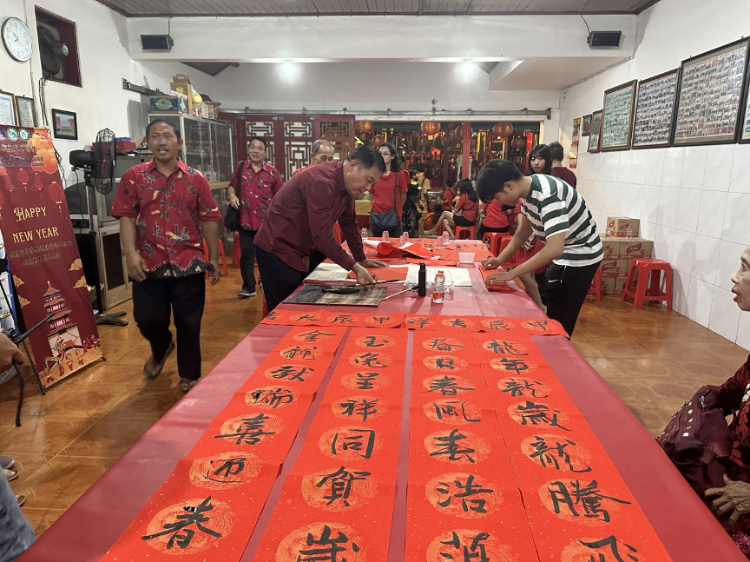 茍皓東為華人朋友現(xiàn)場寫春聯(lián)送福字。巴陵康孔子學(xué)院供圖