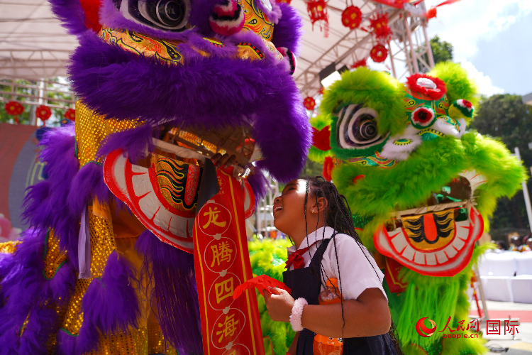 小朋友與舞獅表演者互動。人民網(wǎng)記者 黃煒鑫攝