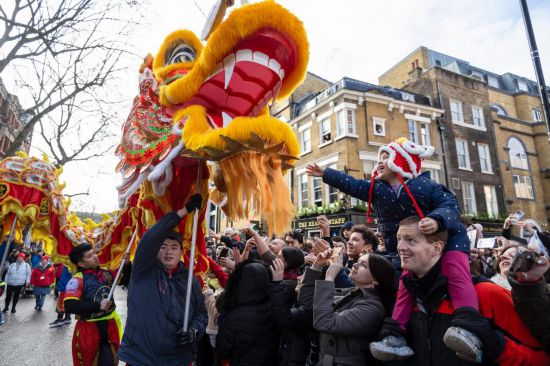 2月11日，人們在英國倫敦的新春巡游活動中觀看舞龍表演。新華社發(fā)（史蒂芬·程攝）