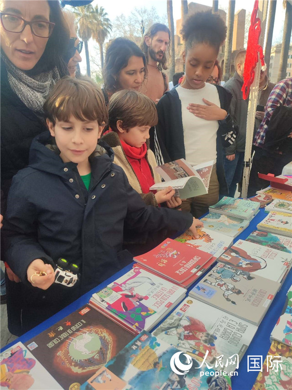 印刷精美的中國傳統(tǒng)文化叢書吸引了小游客的注意。人民網(wǎng)記者鄭彬攝