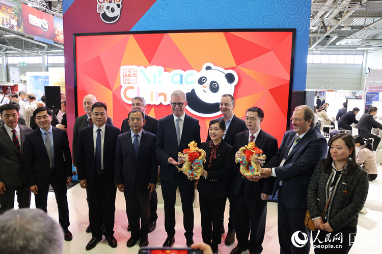 參加中國館開幕式的嘉賓們?cè)凇澳愫?中國” 展臺(tái)前合影留念。