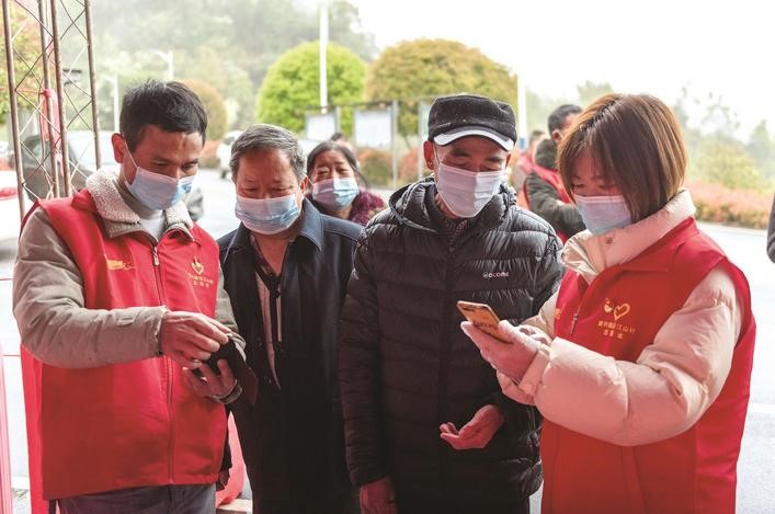 長(zhǎng)沙縣黨員志愿者正在幫助參與核酸檢測(cè)的群眾掃描“場(chǎng)所碼”。劉思源 攝