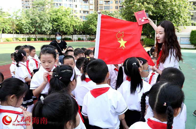 老師向少先隊(duì)員展示隊(duì)旗。人民網(wǎng) 符武平攝