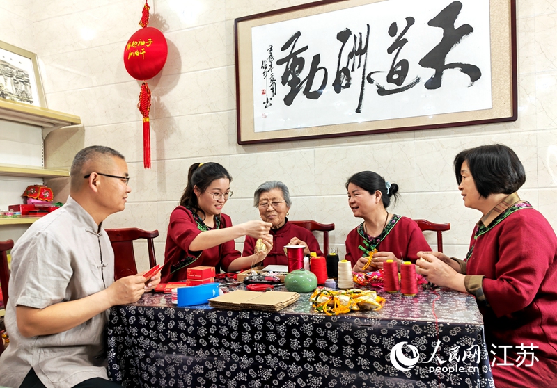 王秀英老人指導(dǎo)孫女制作香包。人民網(wǎng) 閆峰攝