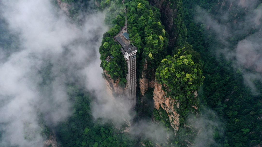 位于張家界武陵源景區(qū)的百龍?zhí)焯蓁偳对谠旗F繚繞的峰林間，雄偉壯觀(guān)。吳勇兵攝