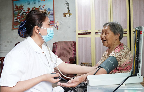 護(hù)理團(tuán)隊(duì)醫(yī)生為老人測量血壓。 陳佳兵攝