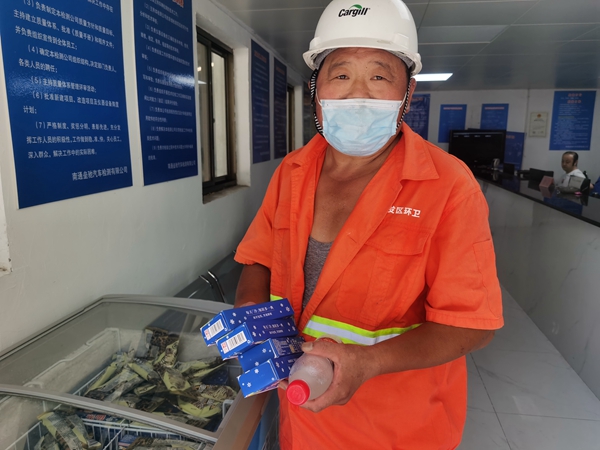 1環(huán)衛(wèi)工倪建宏小憩后，為還同事帶去冷飲。人民網(wǎng)記者王繼亮攝