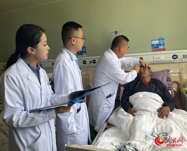 董光明（左三）帶領(lǐng)醫(yī)生對患者進(jìn)行術(shù)前檢查。人民網(wǎng)記者 杜燕飛攝