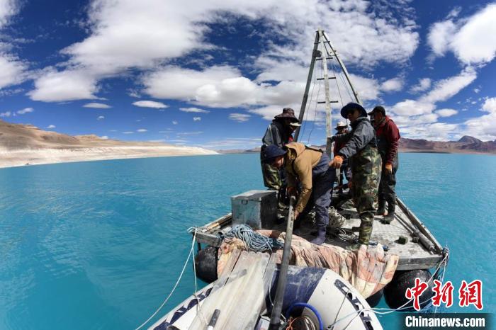 科考隊員在湖泊鉆探平臺上小心搬運采集的巖芯樣品。　<a target='_blank' ><p  align=