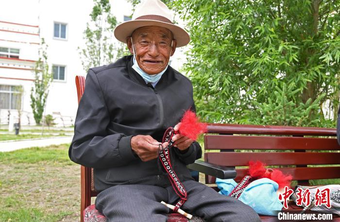 圖為曲松縣特困人員集中供養(yǎng)中心老人在做傳統(tǒng)手工編織?！≮w朗 攝