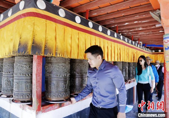 圖為外籍嘉賓體驗藏族傳統(tǒng)轉(zhuǎn)經(jīng)筒?！●R銘言 攝