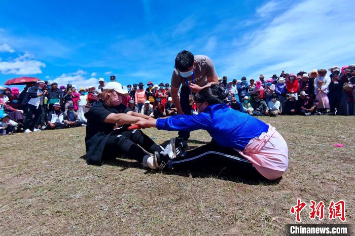 圖為當(dāng)?shù)孛癖娺M(jìn)行蹬棍比賽。　李雋 攝