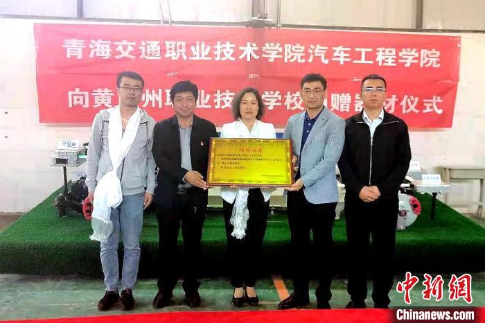 圖為李富香(中)代表學(xué)校為州縣技校捐贈器材。(資料圖) 青海省教育廳供圖