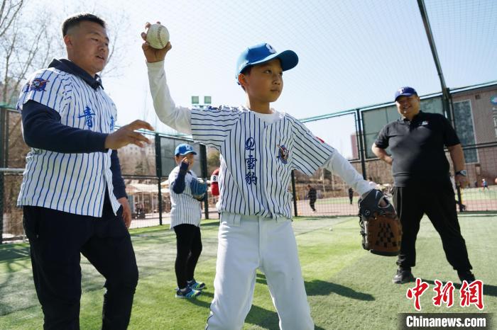 圖為教練指導(dǎo)小棒球手擲球技術(shù)?！●R銘言 攝