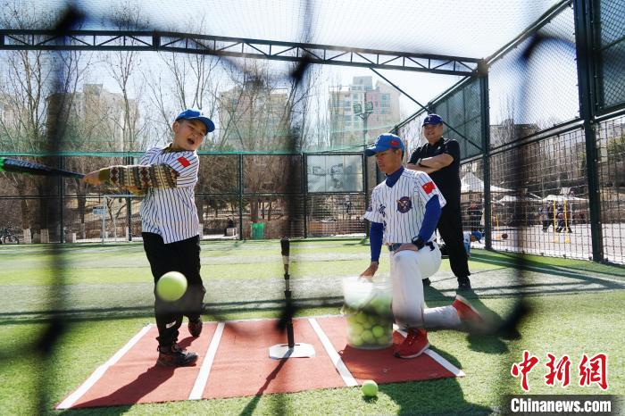 圖為教練指導(dǎo)小棒球手進行擊球訓練?！●R銘言 攝