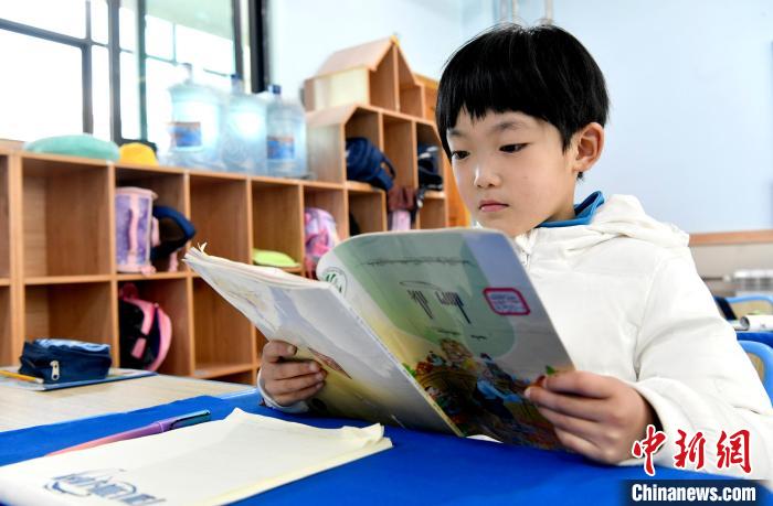 3月14日，西藏拉薩市第一小學(xué)一年級六班學(xué)生丁增樂吉在閱讀藏語課本。　李林 攝