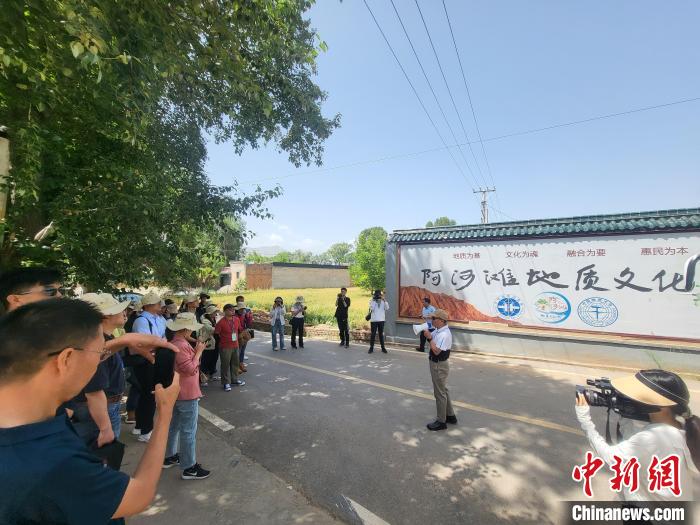 圖為中國地質(zhì)大學(xué)(北京)教授張緒教介紹村落情況?！『衍?攝