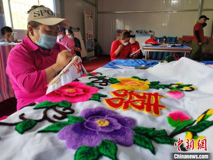 圖為婦女制作青繡?！?zhí)砀?攝